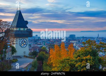 Stadtbild von Graz und dem berühmten Grazer Uhrturm auf dem Schlossberg, Graz, Steiermark, Österreich, im Herbst, Bei Sonnenaufgang Stockfoto