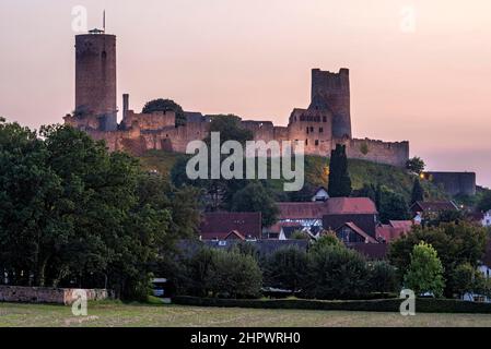 Beleuchtete Burgruinen der mittelalterlichen Stauferburg Münzenberg, auch Münzenburg im Abendlicht mit den Burgtürmen östlich und westlich Stockfoto