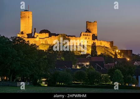 Beleuchtete Burgruinen der mittelalterlichen Stauferburg Münzenberg, auch Münzenburg im Abendlicht mit den Burgtürmen östlich und westlich Stockfoto