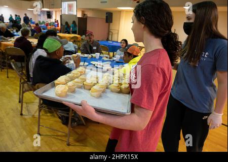 Marietta, Georgia, USA. 13th. Februar 2022. Freiwillige des Studentenministeriums durchstreifen den Speisesaal mit Cupcakes, während die First Baptist Church Marietta während des Super Bowl-Fußballspiels am Sonntag ihr ''˜Big Game'-Dinner veranstaltete. Die Kirche diente Familien und Einzelpersonen, die obdachlos sind oder finanziell kämpfen. (Bild: © Robin Rayne/ZUMA Press Wire) Stockfoto