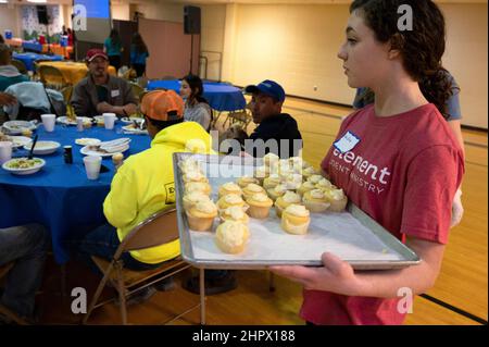 Marietta, Georgia, USA. 13th. Februar 2022. Freiwillige des Studentenministeriums durchstreifen den Speisesaal mit Cupcakes, während die First Baptist Church Marietta während des Super Bowl-Fußballspiels am Sonntag ihr ''˜Big Game'-Dinner veranstaltete. Die Kirche diente Familien und Einzelpersonen, die obdachlos sind oder finanziell kämpfen. (Bild: © Robin Rayne/ZUMA Press Wire) Stockfoto