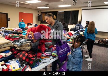 Marietta, Georgia, USA. 13th. Februar 2022. Während der Spielhalbzeit erkunden die Gäste gespendete Schuhe und Kleidung für sich selbst oder Familienmitglieder. Die First Baptist Church von Marietta veranstaltete während des Super Bowl-Fußballspiels am Sonntag ihr ''˜Big Game'-Abendessen, bei dem Familien und Einzelpersonen, die obdachlos oder finanziell zu kämpfen haben, willkommen geheißen wurden. (Bild: © Robin Rayne/ZUMA Press Wire) Stockfoto