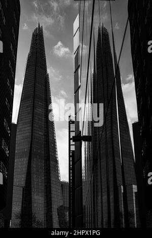 Vertikale Graustufenaufnahme des Shard London mit seiner Spiegelung Stockfoto