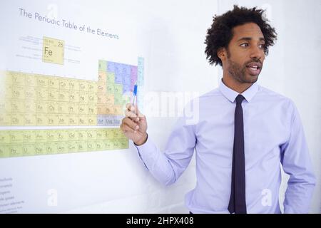 Dieser Wissenschaftslehrer weiß, wovon er spricht. Aufnahme eines männlichen Wissenschaftslehrers, der das Periodensystem erklärt. Stockfoto