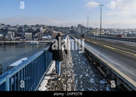 Frau, die im Winter über eine verschneite Brankov Most (Brücke) läuft. Belgrad, Serbien Stockfoto