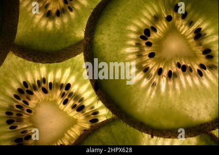 Hinterleuchtete Limettenscheiben in Makrodetails, die Samen und Textur zeigen. Stockfoto