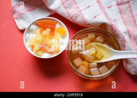 Chinesische Desserts, Milchpudding Obstsalat und Mix Ginkgo Nüsse Cassava Sirup Kokosgelee in longan Saft auf Glasschüssel, Thai und Chinesisch longan Datum Stockfoto