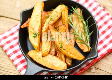 Kartoffelkeile auf dem Teller mit Rosmarinkraut, Pommes Frites kochen oder Kartoffeln braten Stockfoto