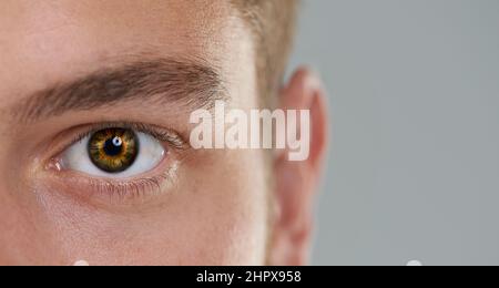 Die Zeit im Auge behalten. Nahaufnahme eines Herrenauges mit einer Uhr im Inneren. Stockfoto