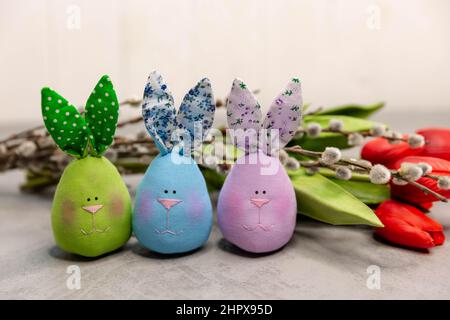 Schöne lustige bunte Ostern Stoff Hasen auf grau. Stockfoto