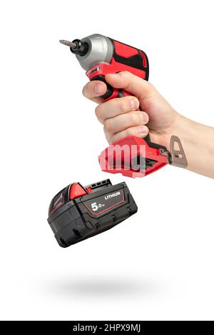 Bohren Sie in der Hand auf einen weißen isolierten Hintergrund. Akku-Bohrschrauber oder Schraubendreher in männlicher Hand. Herausnehmbare Lithium-Batterie wirft Schatten. Das Konzept von Stockfoto