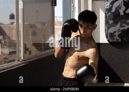 Junge lateinische leichte Boxer Ausbildung in Kampfhaltung Stockfoto