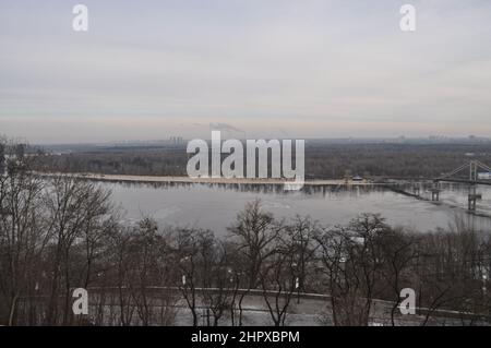 Blick nach Osten über den Dnjepr (Dnipro) von Kiew mit der Fußgängerbrücke (Parkowyi-Fußgängerbrücke) zur Trukhaniv-Insel auf der rechten Seite. Stockfoto