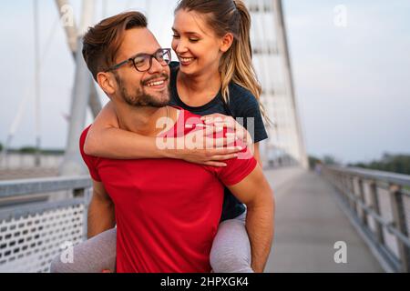 Workout am frühen Morgen. Glückliches Paar, das über die Brücke läuft. Ein gesunder Lebensstil. Stockfoto