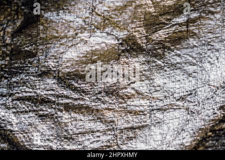 Abstrakt realen Stoff Oberfläche Hintergrund. Aluminium Platinum Silver Folie Tarpaulin Effekt mit rauer Textur Grapfkante. Futurism 80s Retro-Stil neu Stockfoto