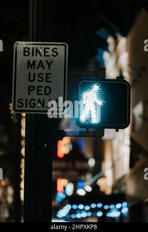 Verkehrszeichen und ein Poster, auf dem steht, dass Fahrräder nachts das PED-Signal verwenden könnten Stockfoto