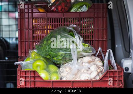 Nahaufnahme der Einkäufe vom Markt Champignons, grüne Äpfel, Gemüse in Verpackungen Stockfoto