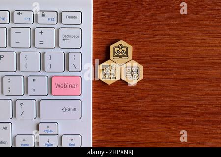 Draufsicht Bild der Tastatur mit Text WEBINAR und Holz-Sechseck-Form mit Webinar-Symbol. Stockfoto