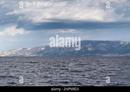 Sonnenflecken auf der Insel Brac in Kroatien von der Adria aus während eines bewölkten Tages Stockfoto