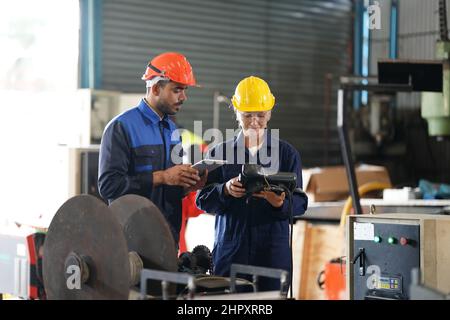 Ingenieur, der das Bedienfeld überprüft und den neuen Roboterarm und die Steuerungsmaschine von Automatics im Werk lehrt. Stockfoto