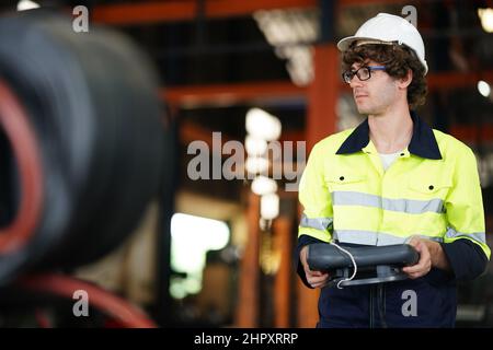 Ingenieur, der das Bedienfeld überprüft und den neuen Roboterarm und die Steuerungsmaschine von Automatics im Werk lehrt. Stockfoto