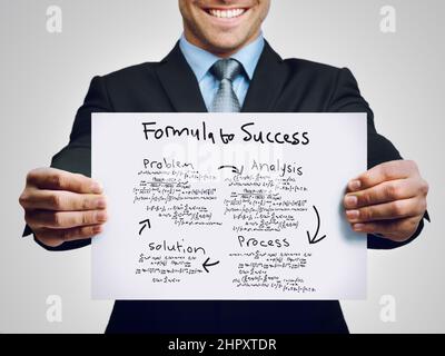 Meine Methode des Erfolgs. Ausgeschnittene Aufnahme eines Geschäftsmannes, der ein Flussdiagramm zu seinem Erfolg hochhält. Stockfoto