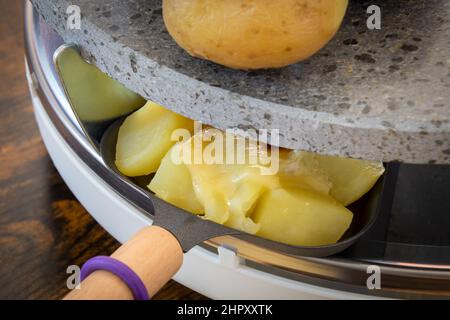 Käse schmilzt in einer Raclette-Maschine aus nächster Nähe Stockfoto