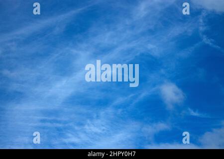 Die Wolken des Cirrus in großer Höhe werden durch Eispartikel in der kalten oberen Atmosphäre gebildet. Winde in solchen Höhen führen dazu, dass die Partikel Wölkchen bilden Stockfoto