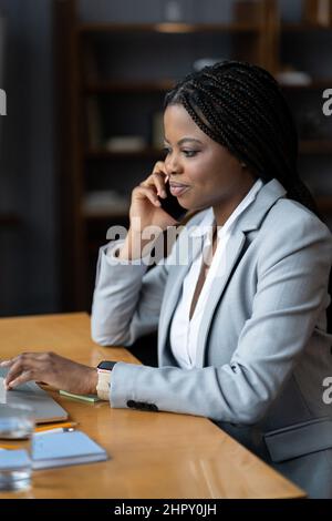Selbstbewusste Geschäftsführerin spricht auf dem Smartphone Telefonieren Sie mit dem Kunden bei der Arbeit im Büro Stockfoto