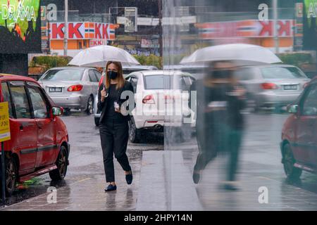 Kuala Lumpur, Malaysia. 24th. Februar 2022. Eine Frau mit Gesichtsmaske geht auf einer Straße in Kuala Lumpur, Malaysia, 24. Februar 2022. Malaysia meldete am Mittwoch um Mitternacht 31.199 neue COVID-19-Infektionen mit der höchsten täglichen Spitzenmarke, was die nationale Gesamtzahl auf 3.305.157 beläuft, so das Gesundheitsministerium. Quelle: Chong Voon Chung/Xinhua/Alamy Live News Stockfoto