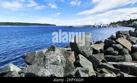 Blick vom felsigen Wellenbrecher der Quadra Island und dem kleinen Yachthafen an einem sonnigen Frühlingstag. Stockfoto