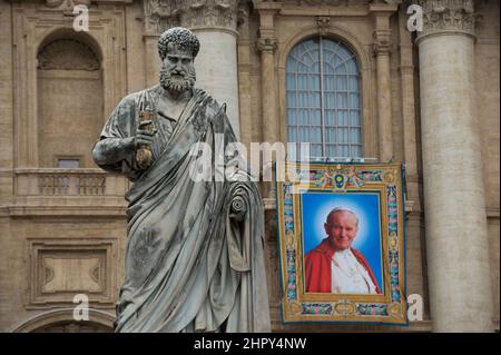 VATIKANSTADT, VATIKAN - 26. APRIL: Auf dem Balkon der Petersbasilika hängt am 26. April 2014 in der Vatikanstadt ein Wandteppich, auf dem der verstorbene Papst Johannes Paul II. Abgebildet ist. Der verstorbene Papst Johannes Paul II. Und Papst Johannes XXIII. Werden am Sonntag, dem 27. April, im Vatikan heilig gesprochen, wenn 800.000 Pilger aus aller Welt anwesend sein werden. ©Andrea Sabbadini Stockfoto