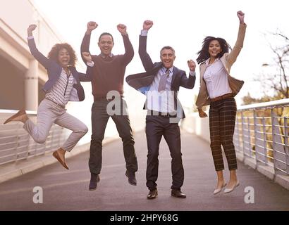 Das triumrihentes Team. Eine Gruppe von Geschäftsleuten, die vor Aufregung springen. Stockfoto