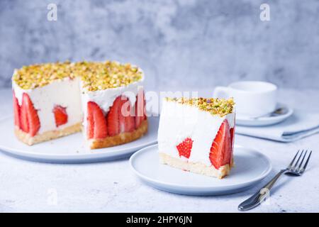 Freesier-Kuchen mit frischen Erdbeeren und Pistazien. Klassisches französisches Dessert. Eine Portion Kuchen auf einem weißen Teller in Nahaufnahme. Stockfoto