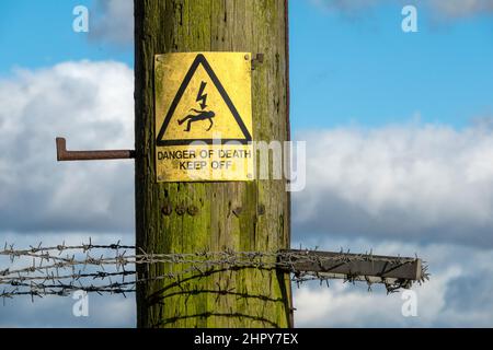 Warnschild „Todesgefahr“ an einem Holzmast angebracht Stockfoto