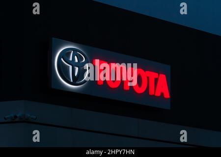 Batumi, Georgia - Januar 26 2022: Nahaufnahme des Toyota Händlerlogos, das abends auf dem Gebäude gegen den Himmel beleuchtet wird Stockfoto