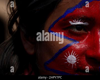 Kathmandu, NE, Nepal. 24th. Februar 2022. Eine Frau malt die nepalesische Nationalflagge auf ihr Gesicht, als sie an einem Protest gegen die MCC-Zuschüsse der US-Regierung für Nepal in Kathmandu, Nepal, am 24. Februar 2022 teilnimmt. Da die Frist der US-Regierung für die parlamentarische Zustimmung des Zuschussdeals näher rückt, haben viele Nepalesen zu gewalttätigen Protesten gegriffen, da sie glauben, dass das Abkommen Nepal zu einem Kompromiss seiner Souveränität führen wird. (Bild: © Aryan Dhimal/ZUMA Press Wire) Stockfoto