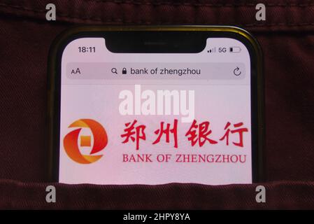 KONSKIE, POLEN - 22. Februar 2022: Das Logo der Bank of Zhengzhou wird auf dem Mobiltelefon in der Jeans-Tasche versteckt angezeigt Stockfoto