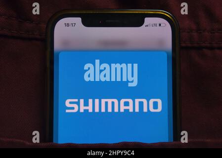 KONSKIE, POLEN - 22. Februar 2022: Das Shimano Inc-Logo wird auf dem Mobiltelefon in der Jeanentasche versteckt angezeigt Stockfoto