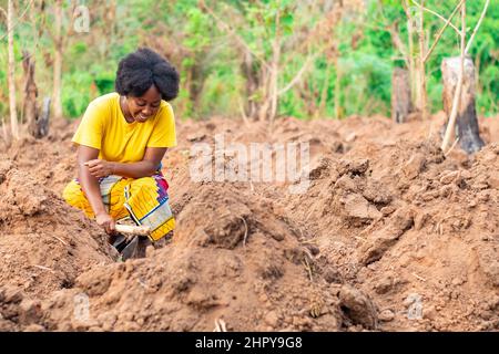 Afrikanische Bäuerin gräbt Grate auf ihrer Farm Stockfoto