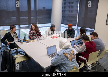 Nahaufnahme von Studenten, die an einem Tisch sitzen und miteinander kommunizieren Stockfoto