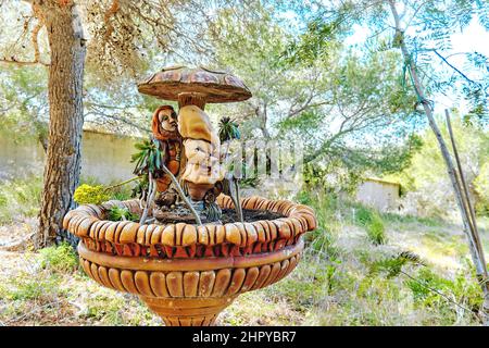 Gnome unter dem Pilz, Brunnen mit Spritzwasser im Freien an einem sonnigen Tag, keine Menschen. Spanien Stockfoto