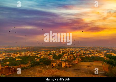 Ein Blick auf Hyderabad, Telangana, Indien, von oben auf der Festung Golconda. Die untergehende Sonne wirft ein bernsteinfarbenes Leuchten auf den Himmel und die darunterliegende Landschaft. Stockfoto