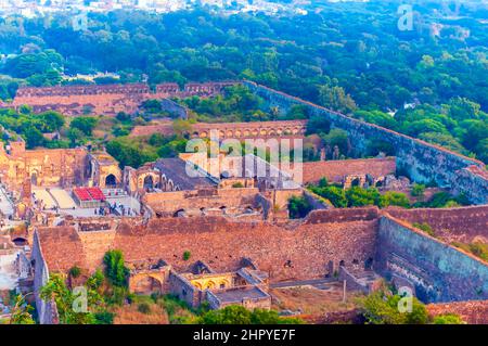 Blick auf die Ruinen der Festung Golconda von der Spitze der befestigten Zitadelle. Verwitterte Granitwände sind sichtbar. Dichte Vegetation schmückt die Landschaft. Stockfoto