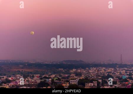 Ein Blick auf die Skyline von Hyderabad in Telangana, Indien, von oben auf dem Golconda Fort. Ein Vollmond erhebt sich über der Stadt der Perlen. Stockfoto