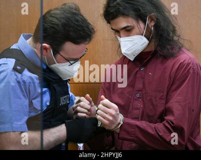 24. Februar 2022, Hessen, Frankfurt/Main: Ein Justizbeamter (l) nimmt dem Angeklagten Franco A. im Gerichtssaal des Oberlandesgerichts Frankfurt die Handschellen ab. Die Bundesanwaltschaft wirft dem ehemaligen Leutnant der Bundeswehr vor, ein schweres Verbrechen vorbereitet zu haben, das den Staat gefährdet. Der Angeklagte soll Angriffe auf Politiker und Künstler aus rechtsextremen Motiven geplant haben. Foto: Arne Dedert/dpa/POOL/dpa Stockfoto