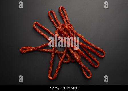 Cabanossi, trockene Wurst isoliert auf schwarzem Hintergrund. Stockfoto