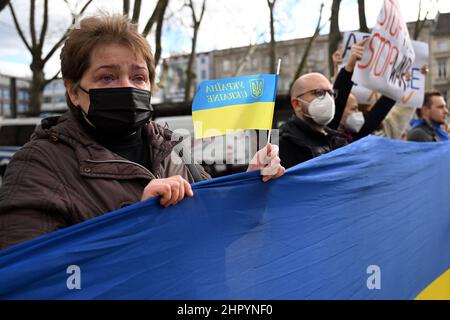 Köln, Deutschland. 24th. Februar 2022. In einer Menschenkette stehen Menschen und halten eine ukrainische Flagge. Mehrere hundert Menschen demonstrieren auf dem Neumarkt gegen den Angriff Russlands auf die Ukraine. Quelle: Federico Gambarini/dpa/Alamy Live News Stockfoto