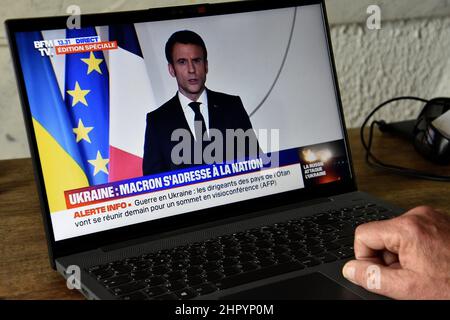 Ein Mann beobachtet Emmanuel Macrons Fernsehrede gegen den Krieg in der Ukraine auf seinem Computer.nach der russischen Offensive in der Ukraine sprach der Präsident der Französischen Republik Emmanuel Macron in einer Fernsehansprache die Franzosen an, um sie über die Situation zu informieren und gleichzeitig diese Aktion von Wladimir Putin aufs Schärfste zu verurteilen. Stockfoto