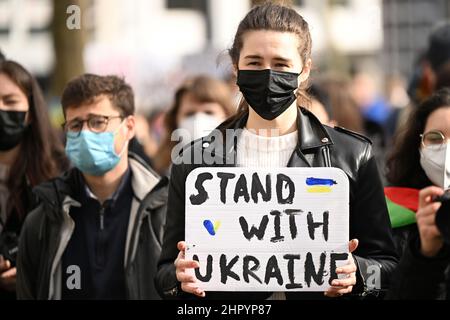 Köln, Deutschland. 24th. Februar 2022. Ein Demonstrator hält ein Schild mit der Aufschrift "Stand with Ukraine". Mehrere hundert Menschen demonstrieren auf dem Neumarkt gegen den Angriff Russlands auf die Ukraine. Quelle: Federico Gambarini/dpa/Alamy Live News Stockfoto